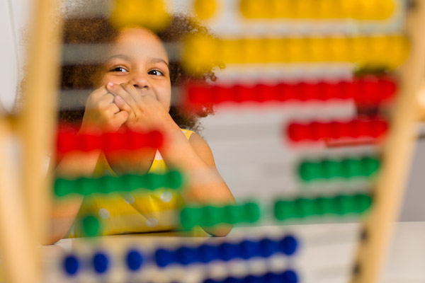 Child peering through abacus